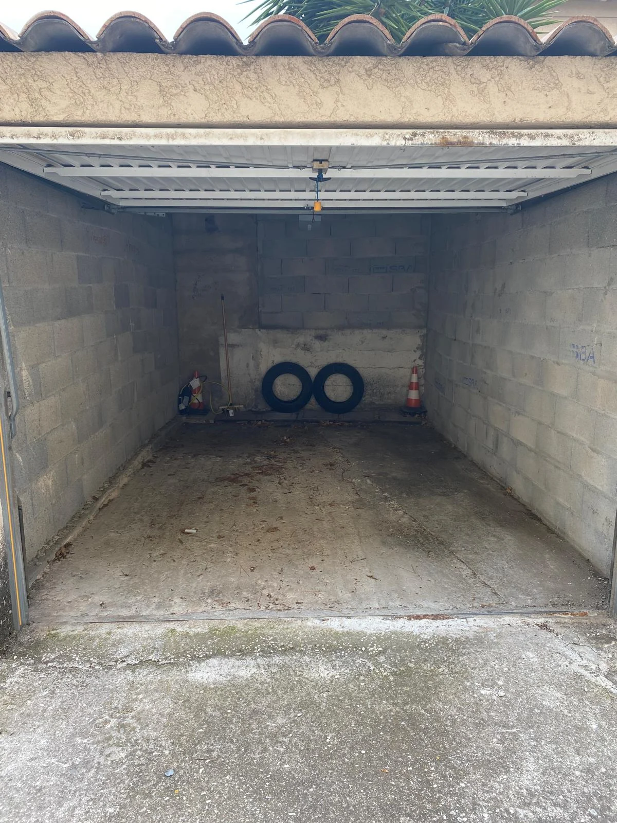 Le même garage avant rénovation : murs et sol bruts
